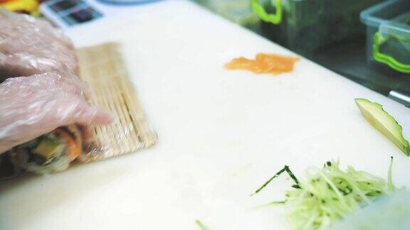寿司日本的食物烹饪烹饪寿司师傅正在用竹席制作寿司卷三文鱼卷特写镜头在餐厅的厨房