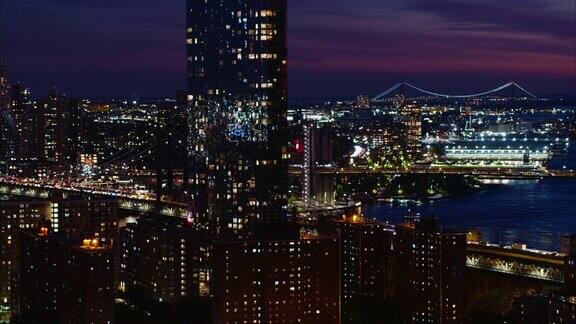 望向曼哈顿大桥、东河上的布鲁克林大桥和远处的维拉萨诺大桥曼哈顿纽约夜晚航拍镜头的平移镜头