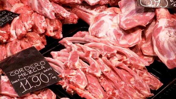 在LaBoqueria市场的一个柜台里托盘里有价格标签的新鲜生肉巴塞罗那西班牙