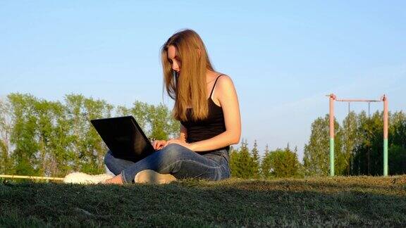 女孩在户外用笔记本电脑工作远程学习自由职业
