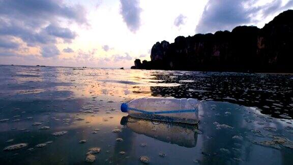 4k:环境污染夕阳下海上的瓶子