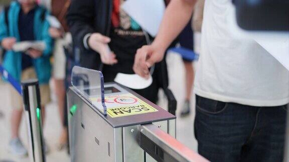 用现代科技检查你的旅行历史使旅行安全在登机口扫描登机牌的旅客在进入安检前紧紧握住他的手看着显示器假期出国旅游