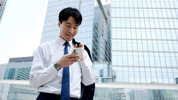 成年韩国商人在办公大楼附近使用手机