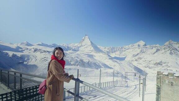 年轻女子在马特洪峰独自旅行时喝着一杯热咖啡