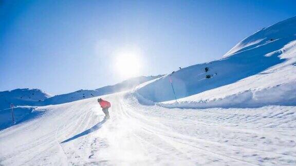 在一个阳光明媚的日子里滑雪者从滑雪坡上滑下来雪花向他喷来