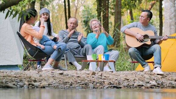 快乐的亚洲大家庭在森林露营唱歌技术家庭生活方式人多代人老年人假期关系假期退休保健和医学概念东南亚及东亚:世代家庭