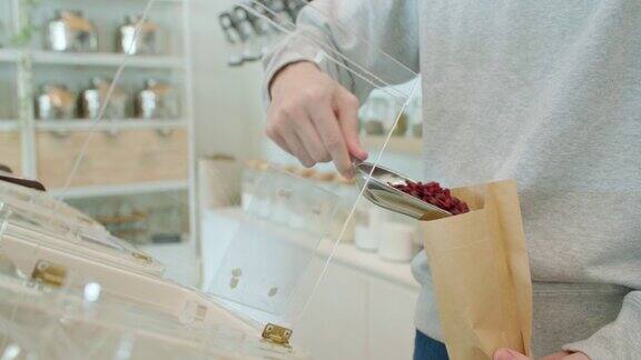 在零垃圾商店一名男子将生物有机食品装入可重复使用的纸袋
