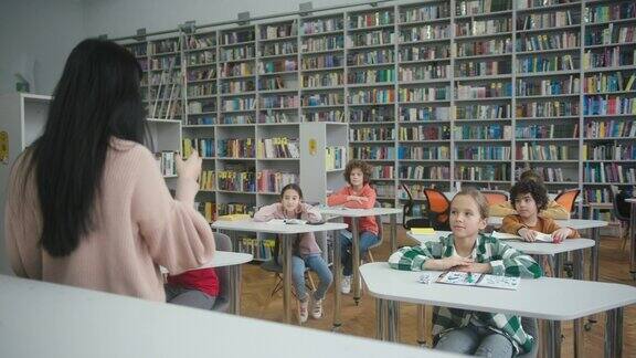 亚洲教师在图书馆向学童讲解