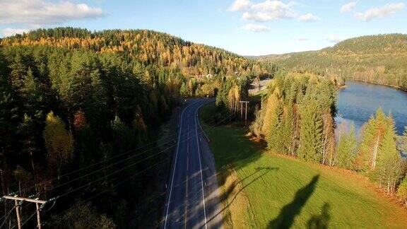 道路与汽车通过秋天的森林河边