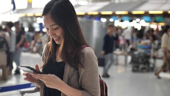 一名女子在机场办理登机手续时使用智能手机