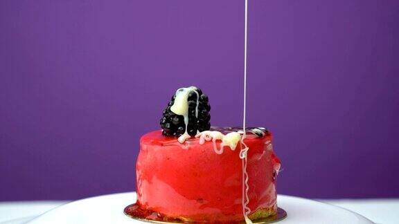 在美味的水果蛋糕上浇上奶油配上白奶油和黑莓片紫色的背景
