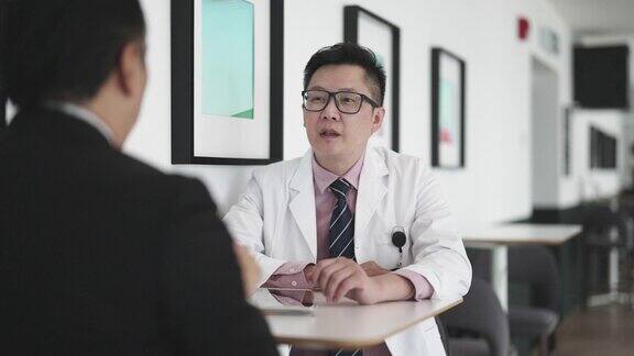 亚裔华人医生与医院管理人员在咖啡厅讨论
