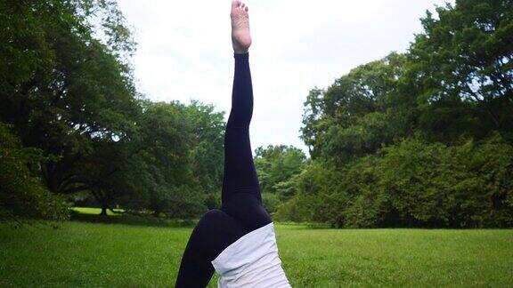 瑜伽教练向空中伸展她的腿