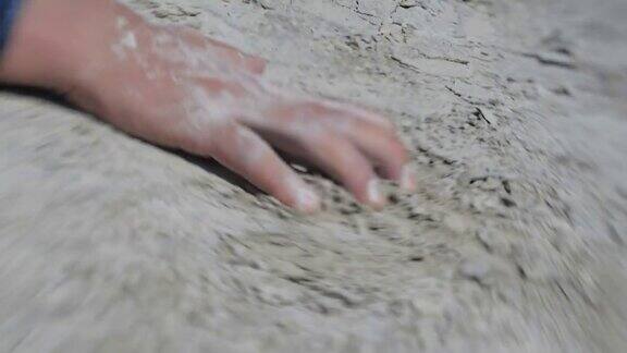 孤独疲惫的旅行者躺在沙漠里一个长头发、穿着脏衣服的人在沙滩上爬来爬去近距离的手镜头宝宝拍摄4k慢动作50帧秒