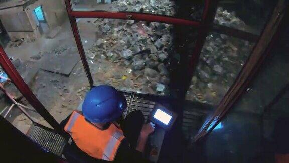 在回收设施的上方升降磁铁操作员将废金属放入碎纸机