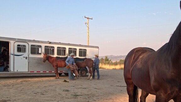两个牛仔准备他们的马骑马在犹他州美国