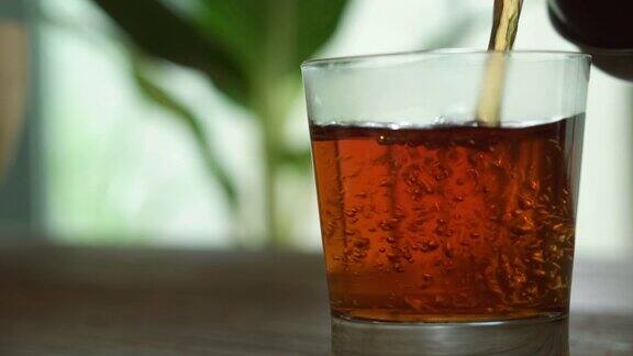 茶水倒在玻璃杯里放在木桌上