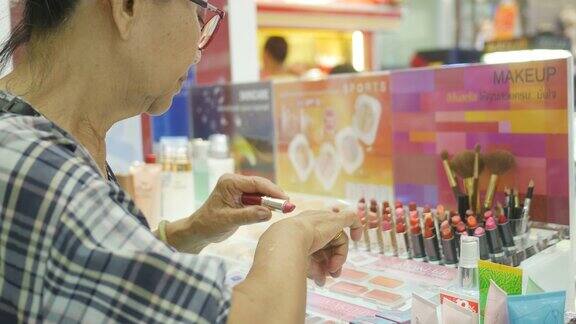 亚洲资深女性在商店试用口红
