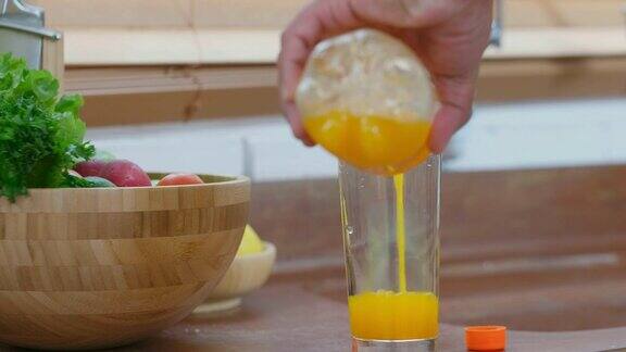 年长的亚洲男人在厨房里倒橙汁在玻璃杯里退休生活方式积极的老年人健康