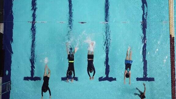 无人机的角度正上方游泳池教练指导她的学生游泳技能