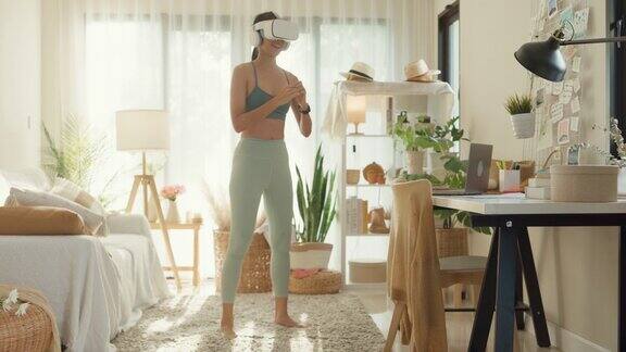 年轻的亚洲运动员戴着虚拟现实耳机在家里的客厅锻炼饮食和健康减肥