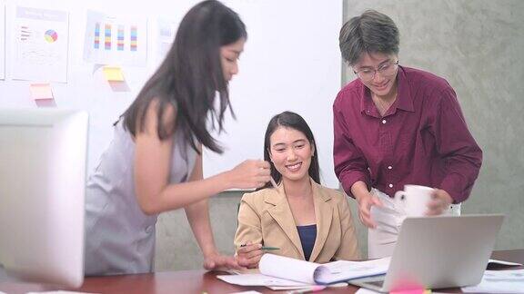 一群亚洲年轻商业女性或办公室女性使用电脑在现代办公室一起讨论工作的4k视频快乐和成功的情绪概念