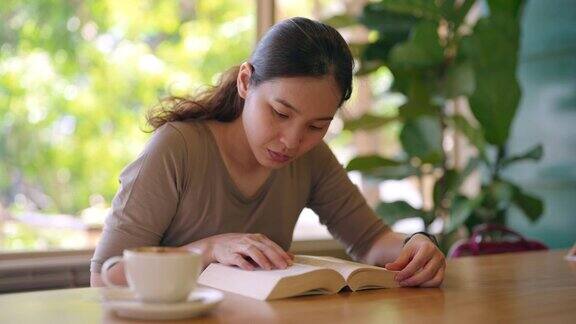 亚洲女人在咖啡店看书