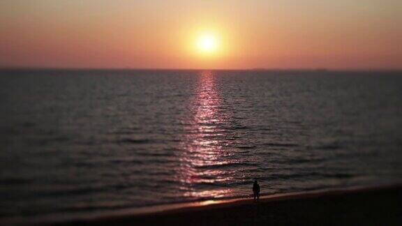一个女人在海边看着夕阳