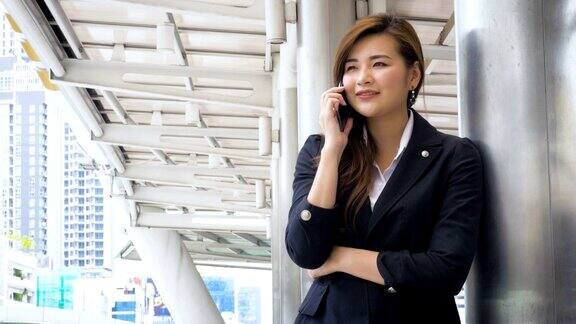 亚洲商人在现代城市里用智能手机打电话