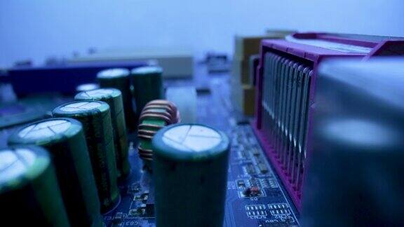 带有芯片、插槽、电容和处理器的计算机主板微电路处于蓝光状态电脑主板电路关闭详细的电子元器件在PC主板