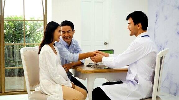 亚洲孕妇和她的丈夫会见产科医生在诊所