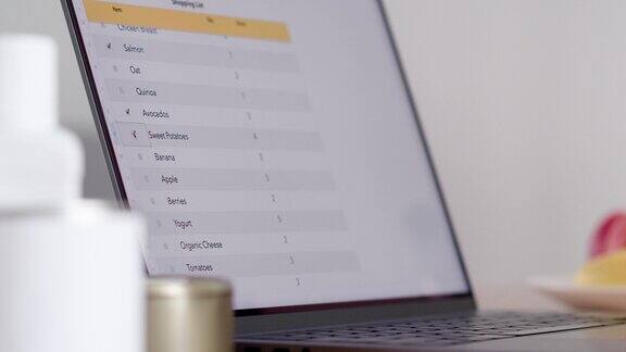 查看笔记本电脑显示屏上的周餐表和购物清单的特写镜头