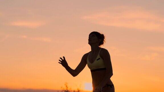 中计划女子排球运动员在日落将一个背球在慢动作
