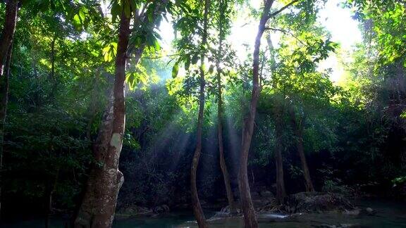 瀑布和美丽的热带自然与阳光透过树泰国北碧府四面瀑布4K分辨率