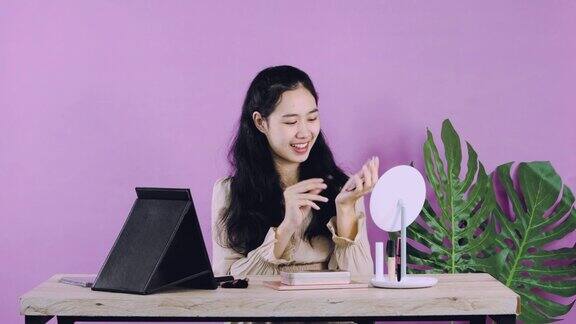 直播年轻的亚洲化妆师视频博主显示化妆品同时在平板电脑相机前在家里工作的视频视频4k