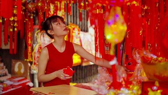 4K亚洲妇女在唐人街市场购买庆祝中国农历新年的装饰饰品
