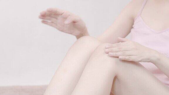 在腿上涂保湿霜的女人身体护理