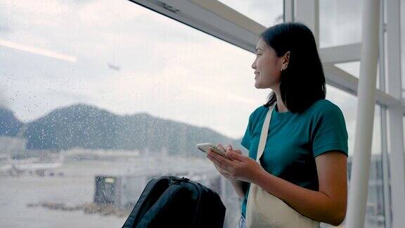 玩手机通讯在候机楼内等候登机的女子旅行