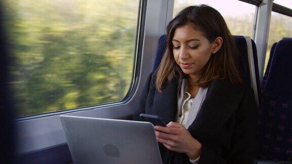 女商人在火车上使用笔记本电脑和电话拍摄的R3D