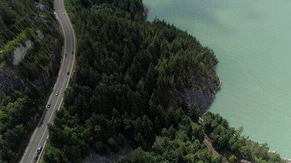 直升飞机在海洋悬崖沿海山区高速公路上飞过汽车