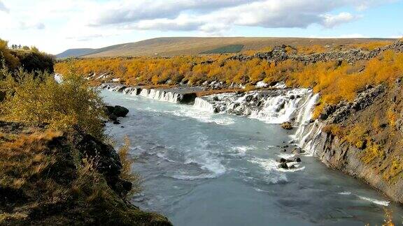 在阳光明媚的秋天冰岛著名的风景如画的Hraunfossar瀑布峡谷