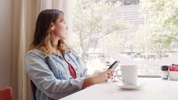 一个迷人的年轻女子坐在咖啡店里发短信的4k视频片段