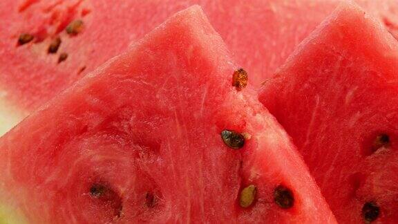 特写多汁的西瓜切成三角形切成红色的西瓜果实放在白色的西瓜上