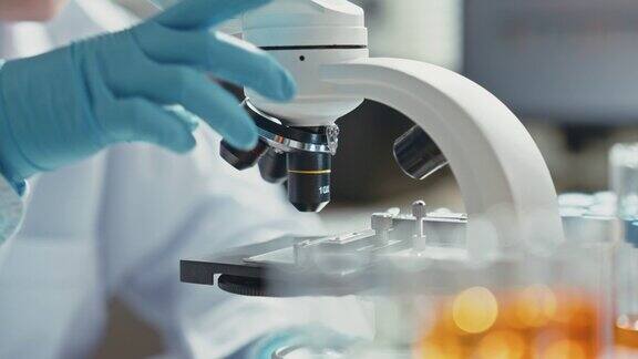 医学研究科学家在生物应用科学实验室的数字显微镜下进行DNA实验