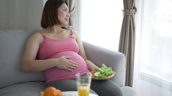 孕妇在家休闲时吃健康食品沙拉、有机食品和果汁