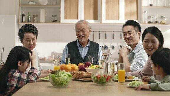 三代亚洲家庭在家里享受美食