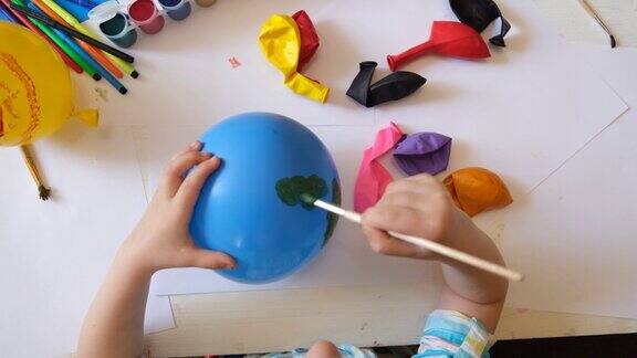 孩子用气球做地球日的行星画一个蓝色的球和绿色的大陆