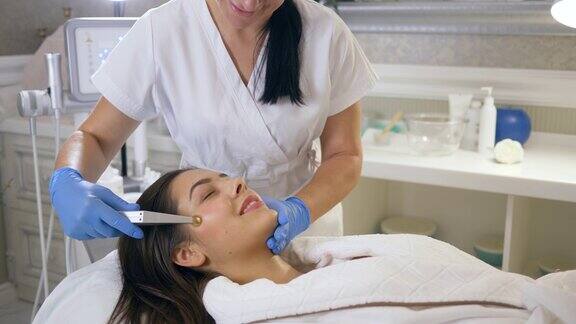 美容师在水疗中心为微笑女孩的皮肤提供纯氧供氧