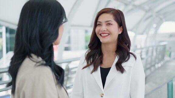 快乐友好的年轻成年亚洲商务女性在办公大楼区域在休息时间聊天商务人士和同事讨论工作