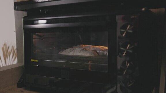 亚洲面包师把生面团放进烤箱里亲手做面包